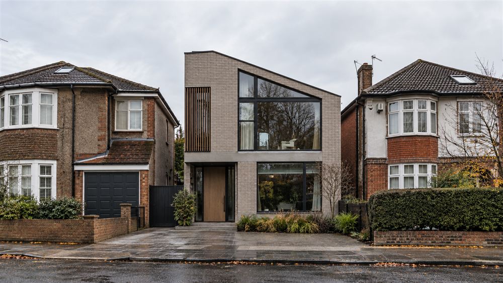 Private Home: a pale brick house with an angled glazed gable on a suburban street